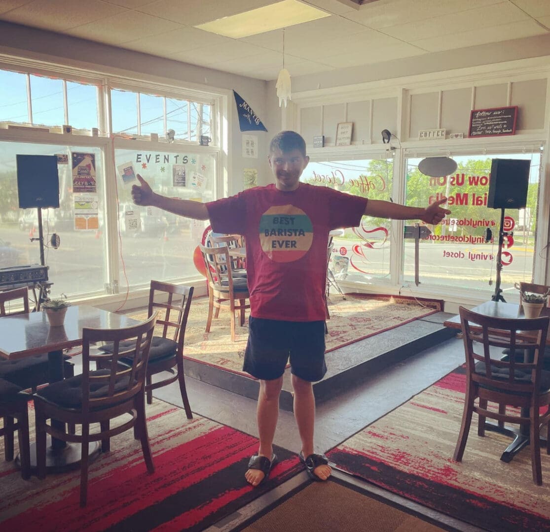 Barista proudly shows off his best t-shirt.