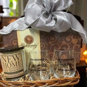 A basket of wine and glasses with a candle.