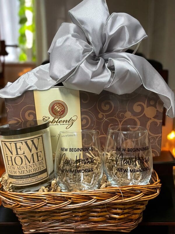 A basket of wine and glasses with a candle.